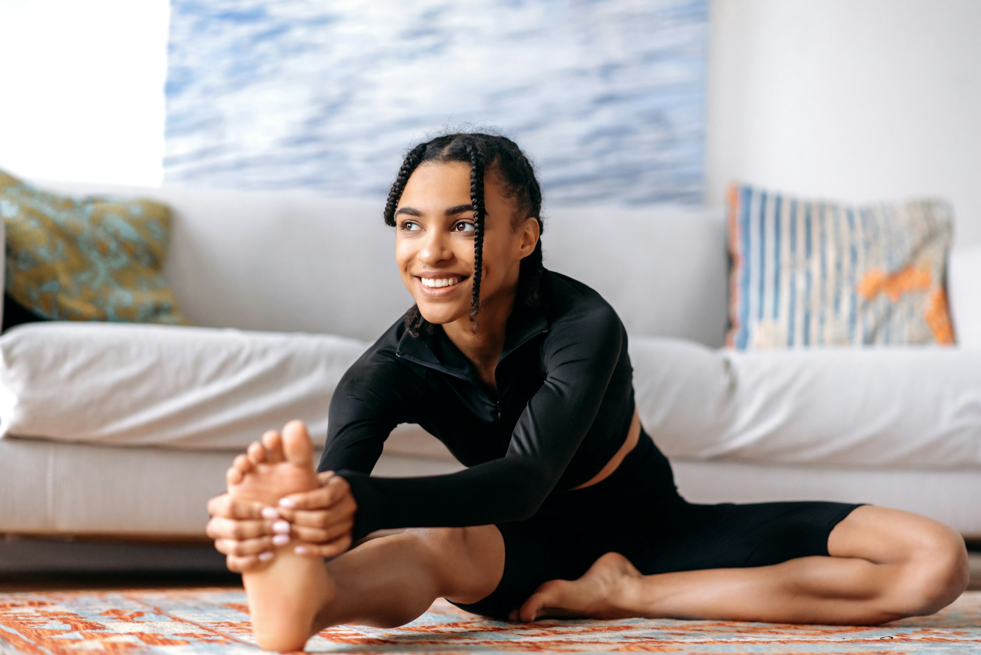 Sporty and flexible pretty African-American girl dressed in sportswear, is engaged fitness